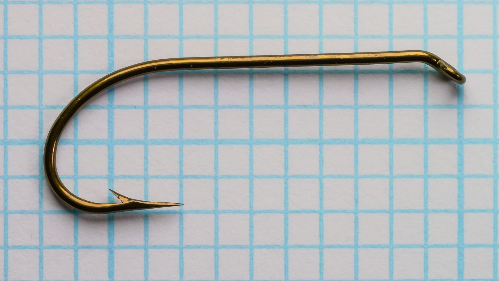 Mustad 3906B size No. 4 — full hook profile — showing extended shank and Sproat bend — top-down view on grid