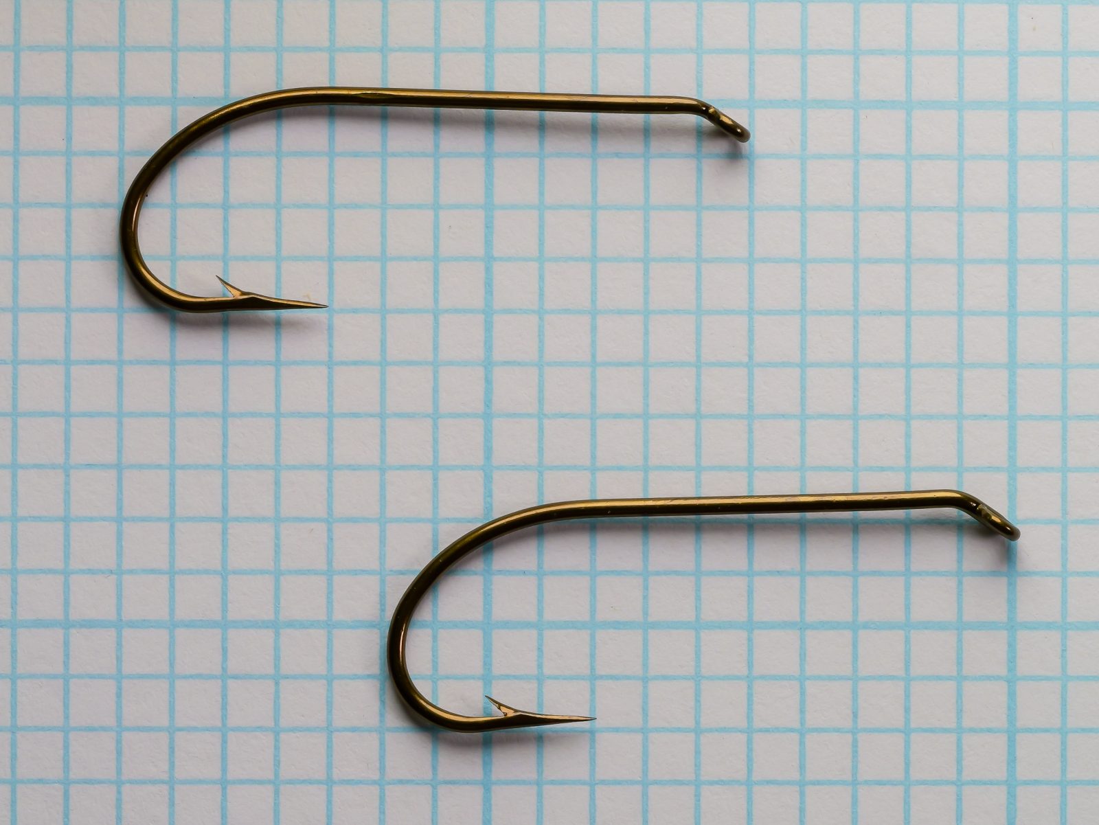 Mustad 3906B size No. 4 — pair of hooks from original card — side-by-side comparison — showing matched manufacturing consistency — on measurement grid