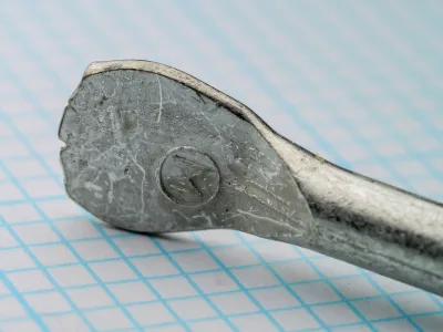 Mustad 722 Flatted Eye — front view showing spade eye terminus with impressed M stamp — size 17/0 — on measurement grid