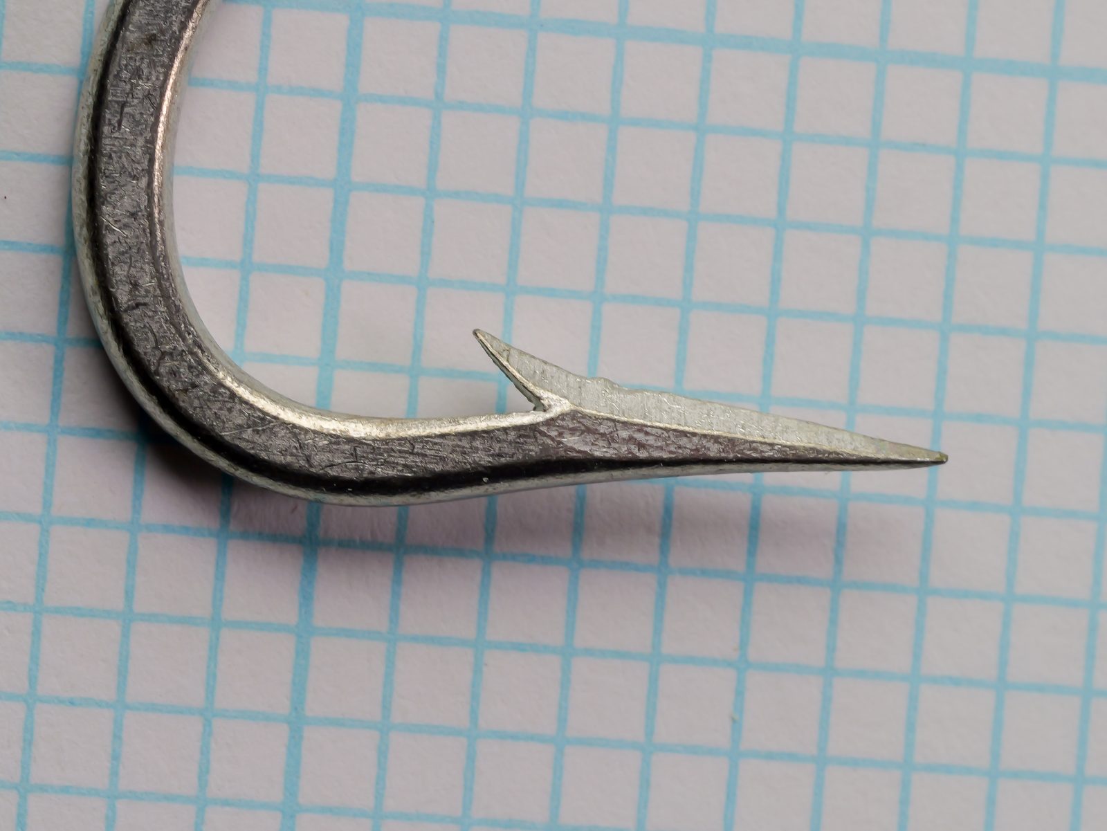 Mustad 7754 Bay King Hook — close-up of knife-edge point geometry — size 7/0 — showing two-faceted cutting edge and barb placement
