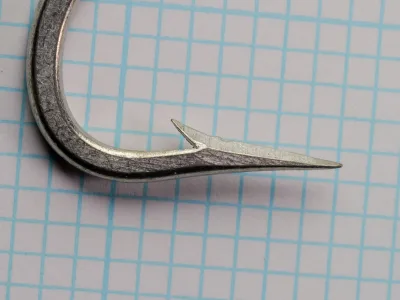 Mustad 7754 Bay King Hook — close-up of knife-edge point geometry — size 7/0 — showing two-faceted cutting edge and barb placement