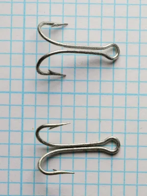 Mustad 7825 T Double Loose Hooks — multiple specimens showing consistency of double-hook configuration and ringed eye alignment — size No. 8 — tinned batch on grid
