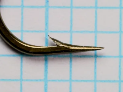 Mustad 7957 BX — detail of hook point showing concave hollow-point geometry and barb angle — bronzed finish — size No. 2
