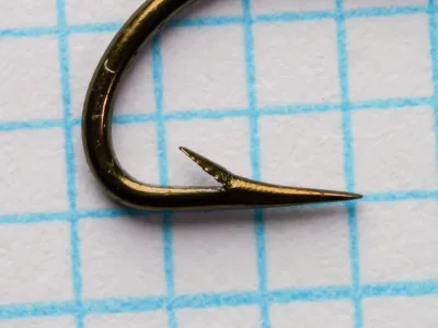 Mustad 9009 Size 8 Limerick bend and Hollow point — lateral view showing the sharp angular bottom bend, barb placement, and concave hollow-point geometry