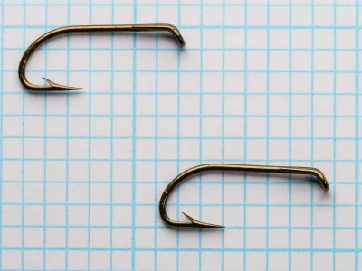 Mustad 9009 Size 8 — two hooks shown for comparison and scale — overall length and gap width measurements on grid