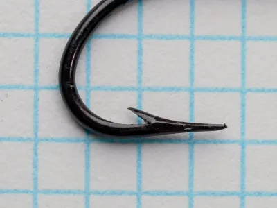 Mustad 9049 — close-up of hook point showing hollow geometry and barb — size 6 — japanned black finish