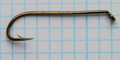 Mustad 92621 hook full profile — side view showing long shank, beak bend, and turned-down small ball-eye — two hooks displayed for comparison