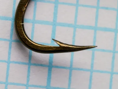 Mustad 9557 Hook — point detail showing hollow-ground edge and reversed offset — size No. 4 — profile view with fine measurement grid
