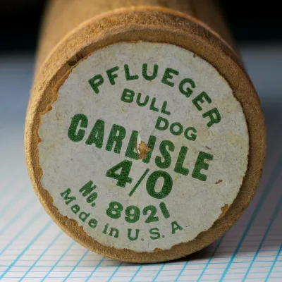 Pflueger wooden tube packaging — printed label end cap — showing model number 8921, Carlisle, size 4/0, Made in USA