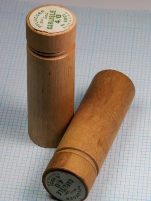 Pflueger wooden tube packaging — full tube and end cap assembly — showing natural wood construction and label positioning