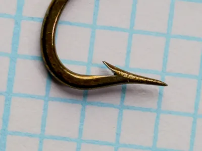S. Allcock No. 790 O'Shaughnessy size 12 hook — right-side view showing superior point geometry — bronzed finish on measurement grid