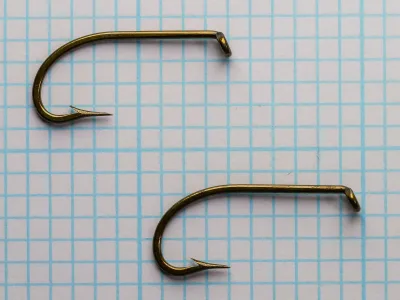 S. Allcock No. 790 O'Shaughnessy size 12 hooks — pair showing consistency — bronzed finish on measurement grid