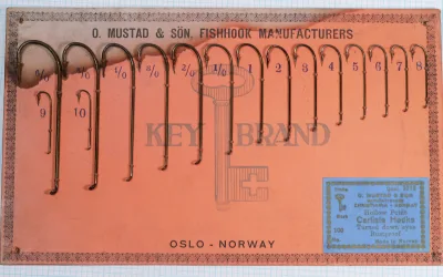 Mustad 3715 complete display card — orange backing with Oslo-Norway designation — full size progression from 6/0 to 10 visible — Key Brand logo watermark