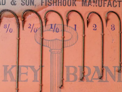 Mustad 3715 Carlisle display card — mounted hooks showing size progression from 6/0 to 3 — complete hook population visible — size 2/0 specimen prominent