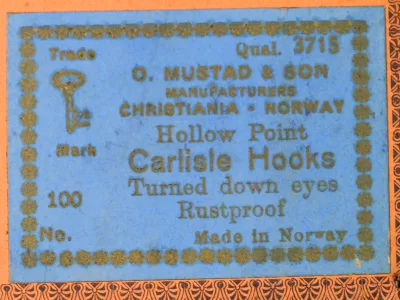 Mustad 3715 specification label — blue card with 'Qual. 3715' and Christiania-Norway location — hollow point and rustproof designation visible