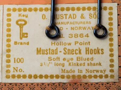 Mustad 3864 label detail — eight-line Mustad format showing Qual. 3864, Hollow Point, Sneck Hooks, Soft Eye Blued, 3 1/2 long Kinked shank, Made in Norway