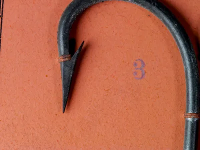 Mustad 7860 Virginia Hook size 3 — point detail showing superior point geometry and tinned finish — close-up on measurement grid