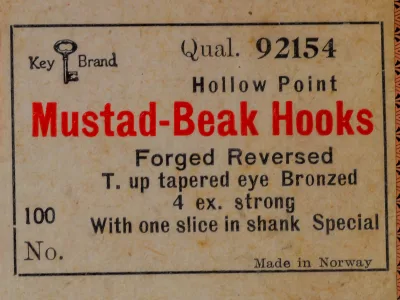 Mustad 92154 printed label — quality code, specifications, and manufacturing details — cream stock with red and black letterpress