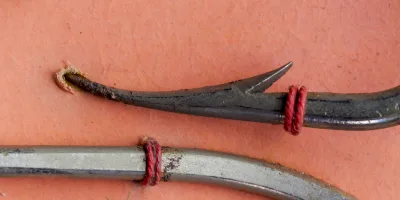 Mustad 92600 Beak Hook — close-up of point geometry showing hollow point and barb — size 4/0 specimen — reversed offset detail on measurement grid