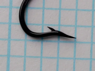 Partridge CS10 Size 6 — right-side profile showing point and barb geometry — bright japanned black finish — superior point taper visible against grid background