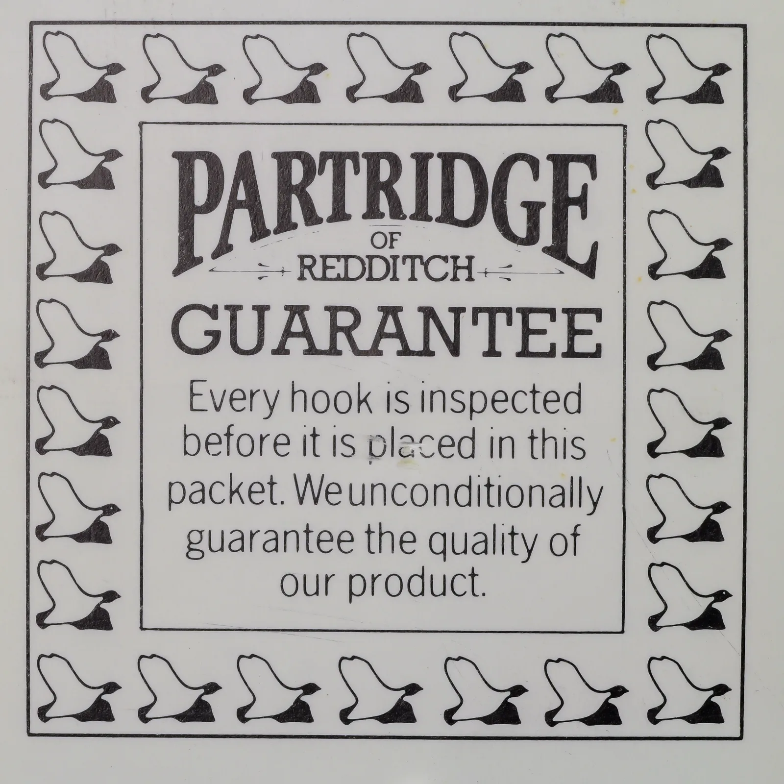 Partridge CS2 BL Size 10 — front face of circular guarantee card packet — showing letterpress-printed border of hook illustrations and central guarantee text — c. 1960s Redditch production