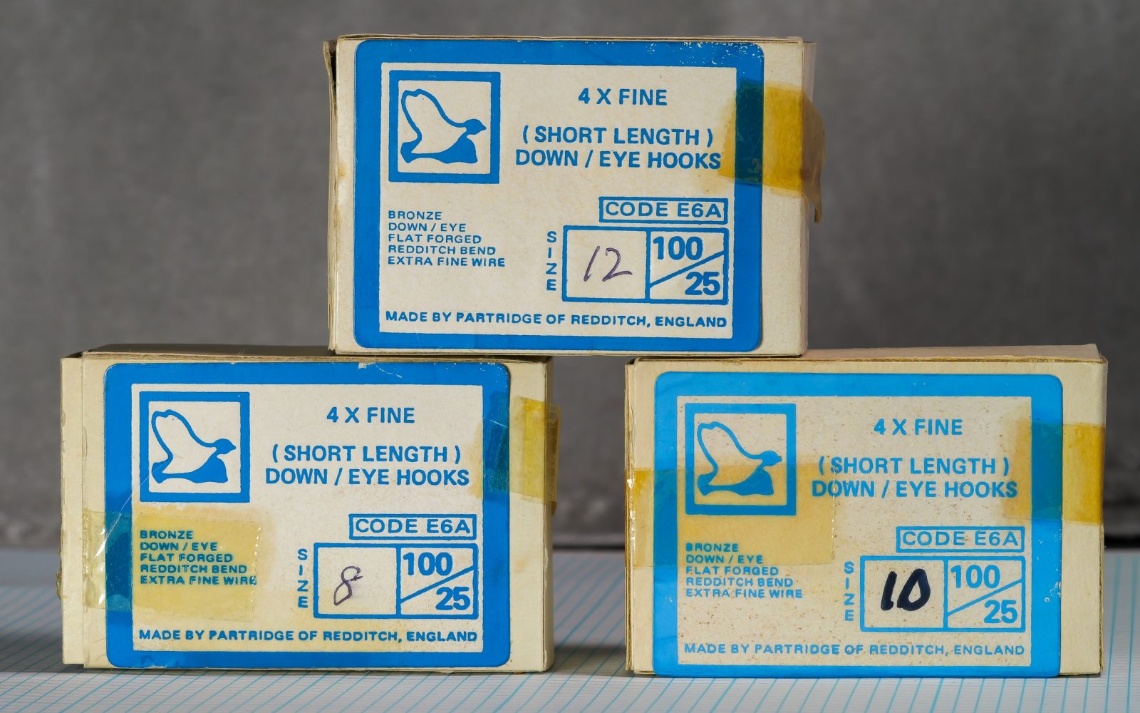 Partridge E6A Size 10 — three boxes stacked showing consistency of original factory packaging — bronze finish hooks