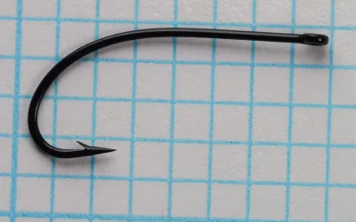 Partridge K12ST size 12 hook — full profile showing straight ring eye and extended shank — black finish — on measurement grid