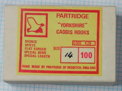 Partridge K2B Yorkshire Caddis Hook — front label showing lime-green and red printed box with flying-duck logo, model code, and handwritten size notation