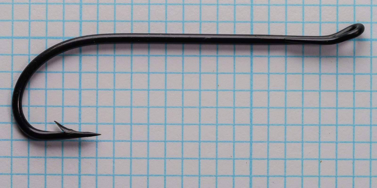 Blued salmon hook curved profile with eye detail on grid pattern