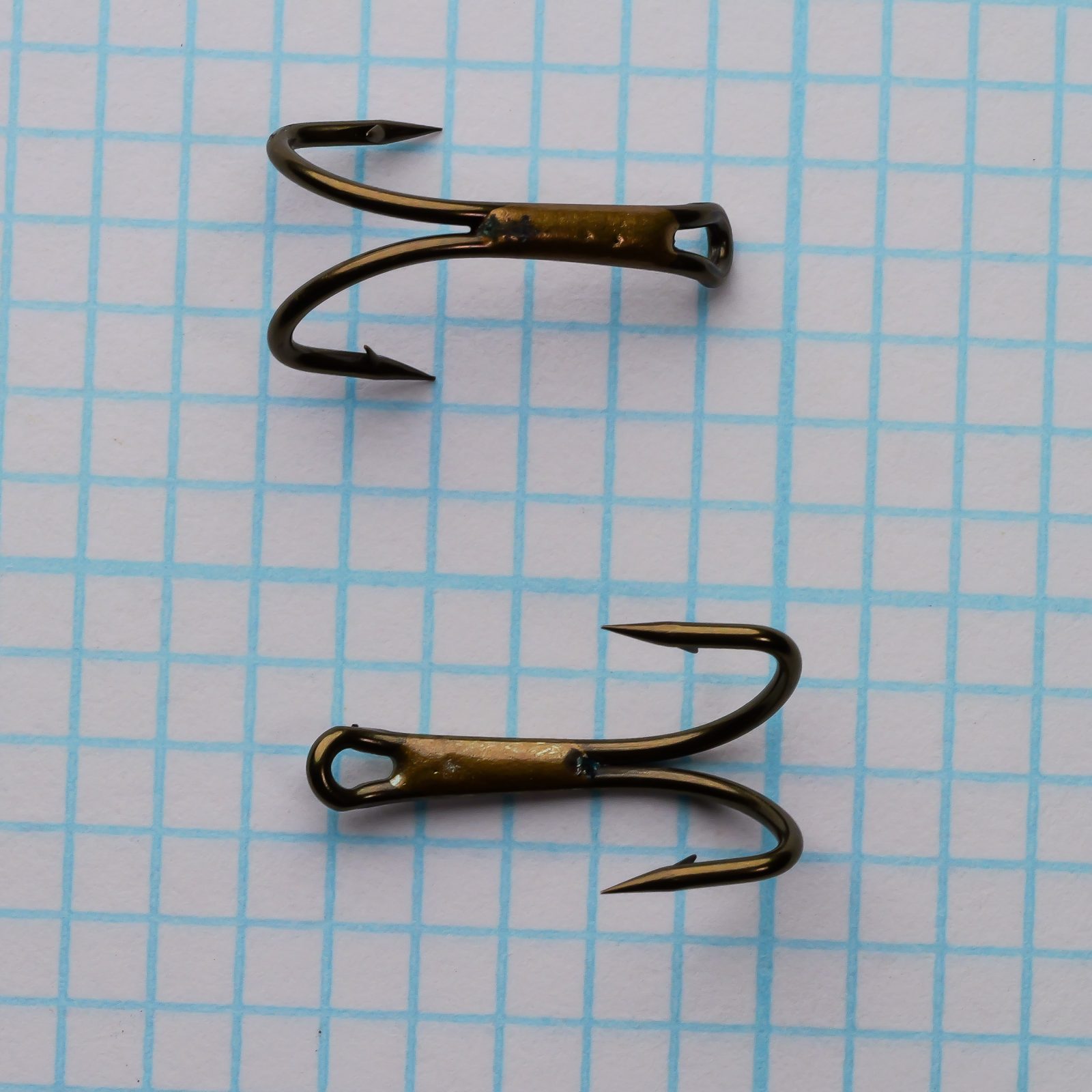 Partridge R1A — three loose specimens showing individual hook point geometry and barb placement — size 10 — bronzed