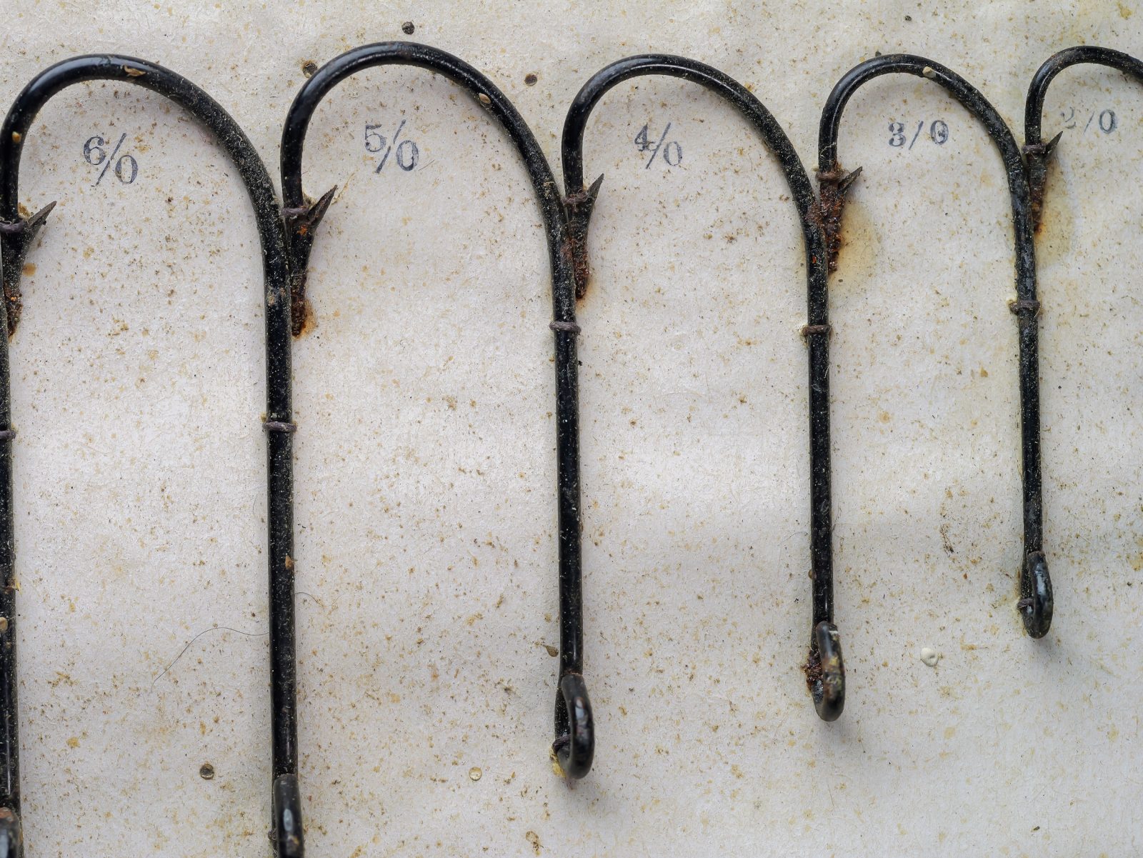 Pflueger Kirby sales card — detail of mounted hooks showing 6/0, 5/0, 4/0, 3/0, 2/0 sizes in graduated sequence with hand-written size notations