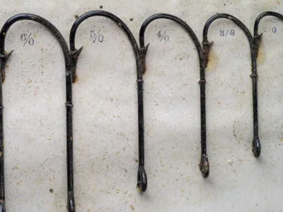 Pflueger Kirby sales card — detail of mounted hooks showing 6/0, 5/0, 4/0, 3/0, 2/0 sizes in graduated sequence with hand-written size notations