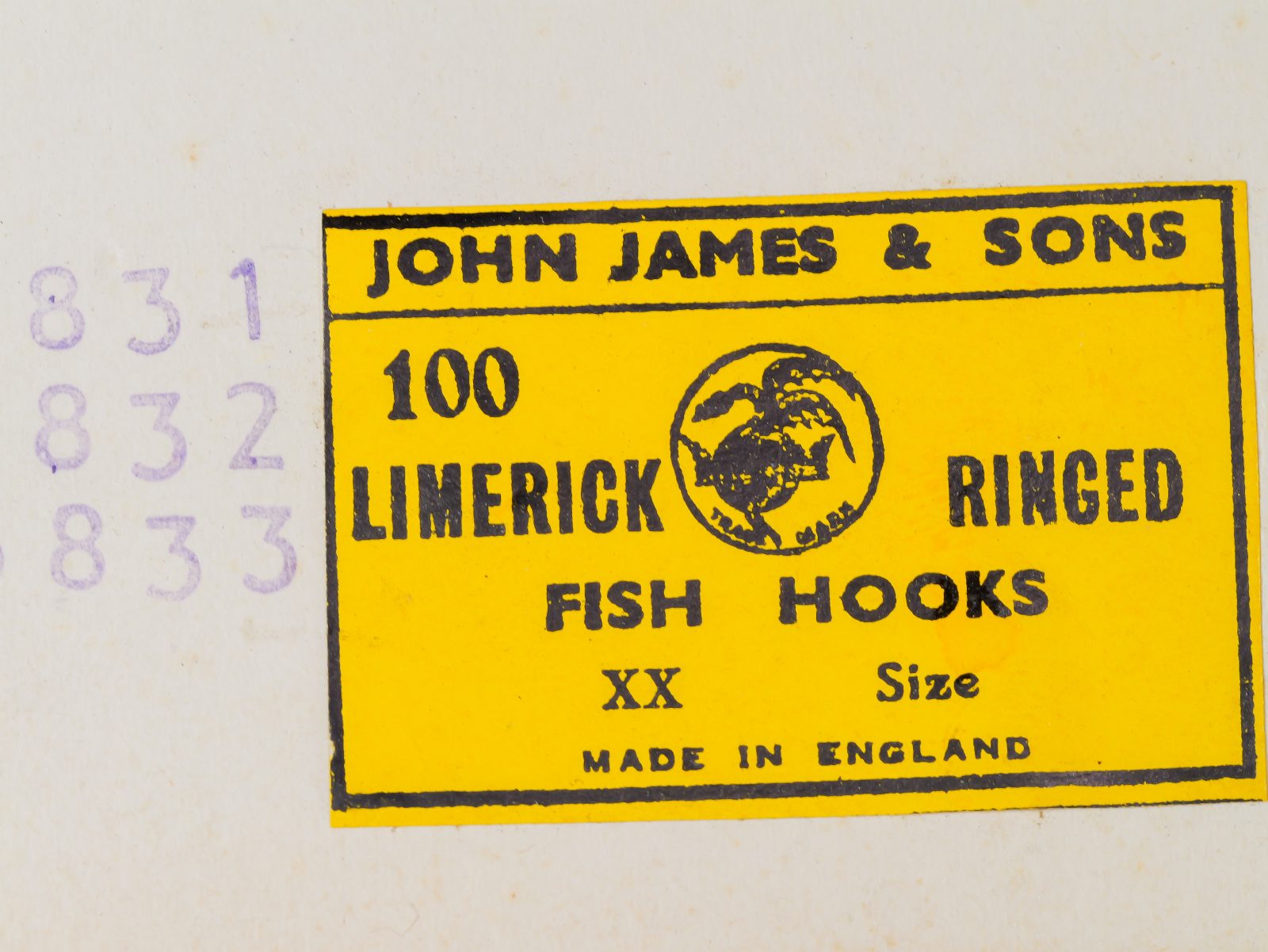 John James & Sons Sales Card Label — yellow printed stock with black letterpress text — '100 Limerick Ringed Fish Hooks' — globe manufacturer logo — 'XX Size' designation — 'Made in England'