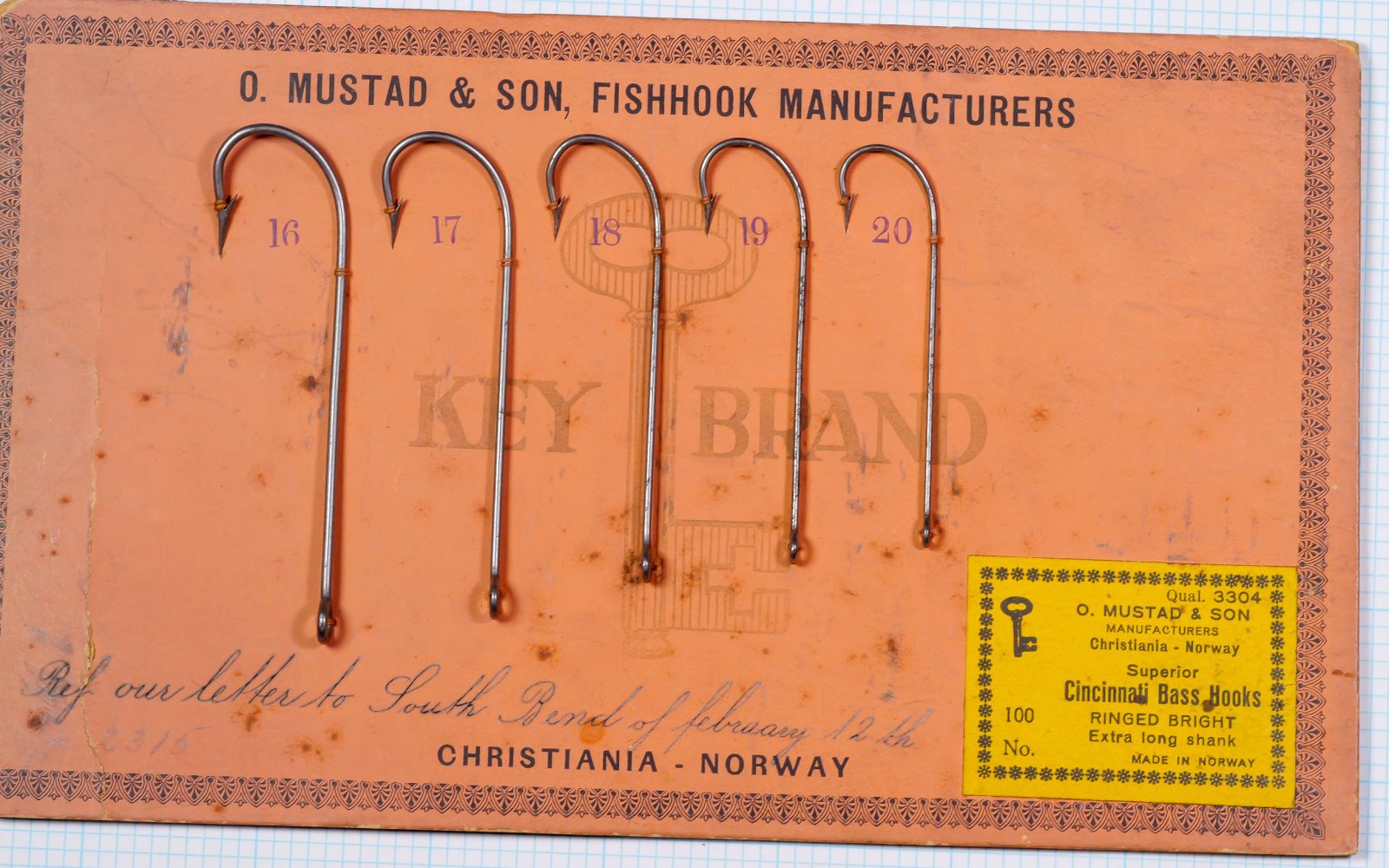 Mustad 3304 specimen card — full view — handwritten South Bend reference — orange backing paper