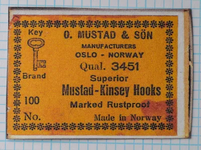 Mustad 3451 Original Packaging Label — orange cardstock with black text and snowflake border — Key Brand trademark and eight-line format — Oslo - Norway address