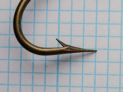 Mustad 3785 — hook point close-up showing hollow point geometry — size 3/0 — sharp concave taper and barb angle