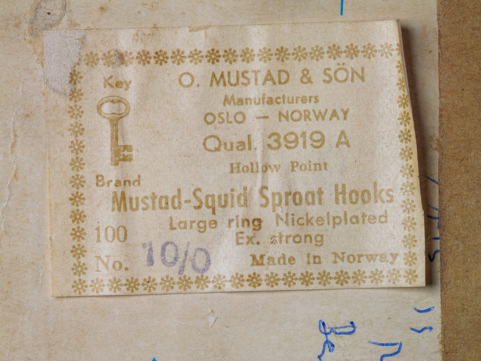 Mustad 3919 A — Original sales card label front — Size 10/0 — Gold letterpress text on cream card with ornate floral border, showing specifications and Key Brand logo