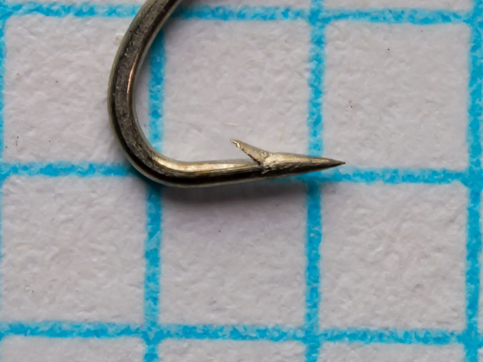 Partridge K14ST Size 16 — side profile showing the superior point, limerick bend geometry, and bright-steel finish — hook measured on grid