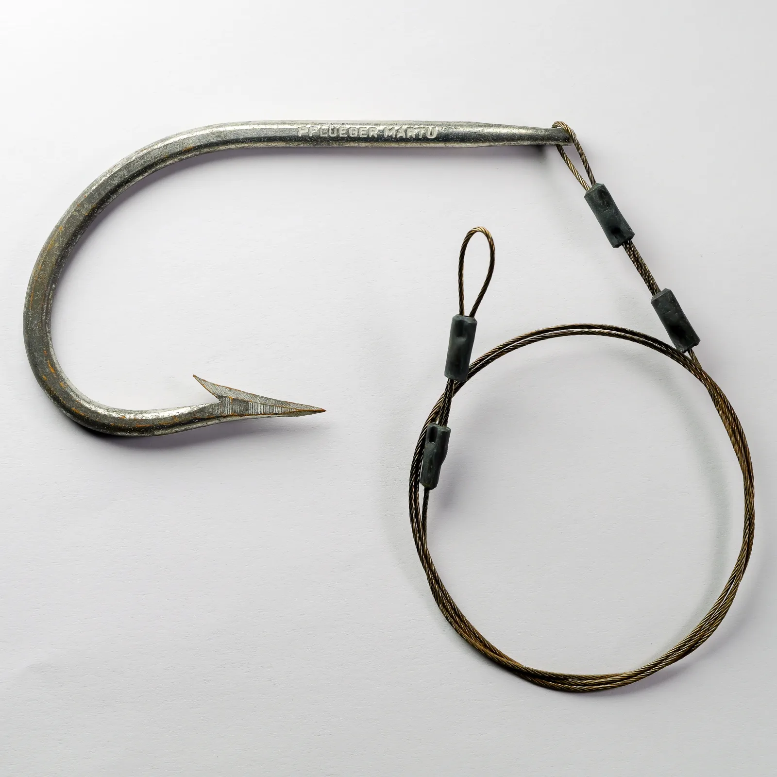 Pflueger Martu Hook size 10/0 — full profile view showing looped eye, long forged shank, and tinned finish on measurement grid