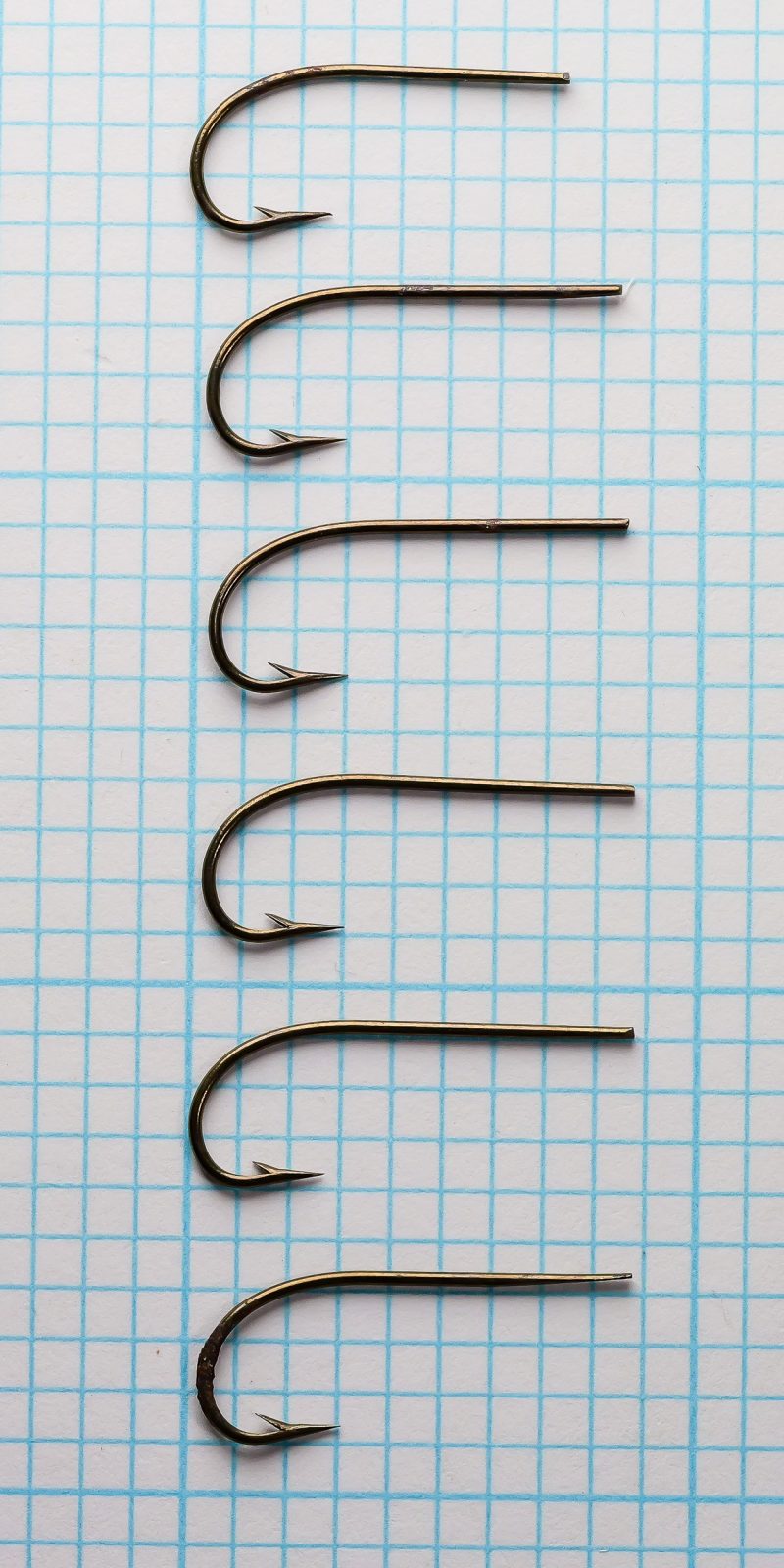 Wm. Bartleet & Sons M64 Sproat Size 6 — six hooks arranged vertically on measurement grid showing overall size consistency and tapered blind eye construction
