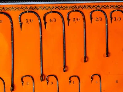 Kendal Sneck hooks sizes 5/0 through 1/0 — upper row detail showing larger fly-hook sizes and blued finish under even lighting