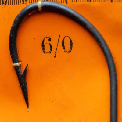 Wm. Bartleet M58 Archer Carlisle Ringed hook point detail — close-up showing japanned finish, superior point geometry, and straight eye ring on measurement grid, size 5/0