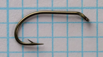 Herter's Celebrated No. 993 Hook Size 12 — front profile showing sproat bend, needle point, and bronzed finish on measurement grid