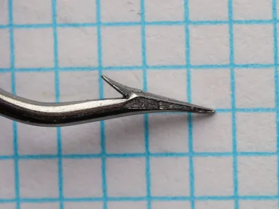 Mustad 3311 — close-up side profile of hook point — No. 17 — showing Kirbed offset and bright steel finish