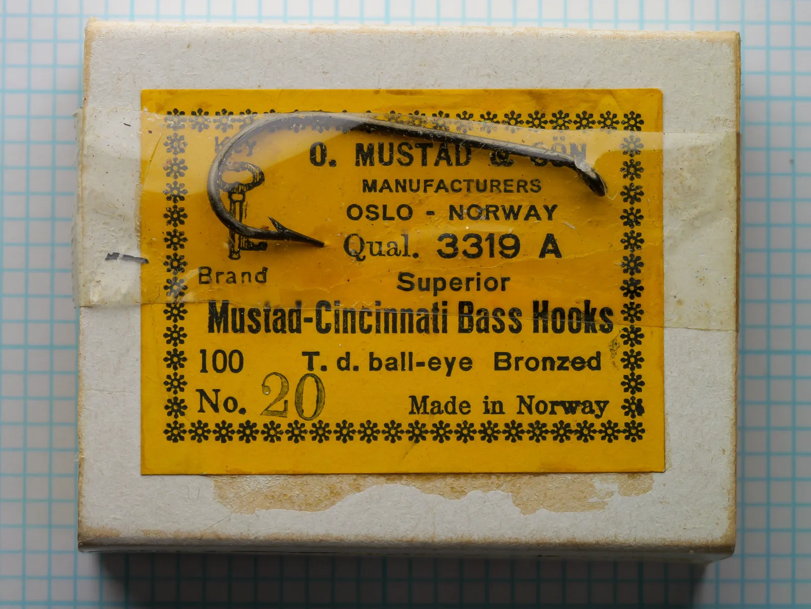 Mustad 3319 A — yellow-labeled packaging card with sample hook, size 20 — c. 1950s–1960s