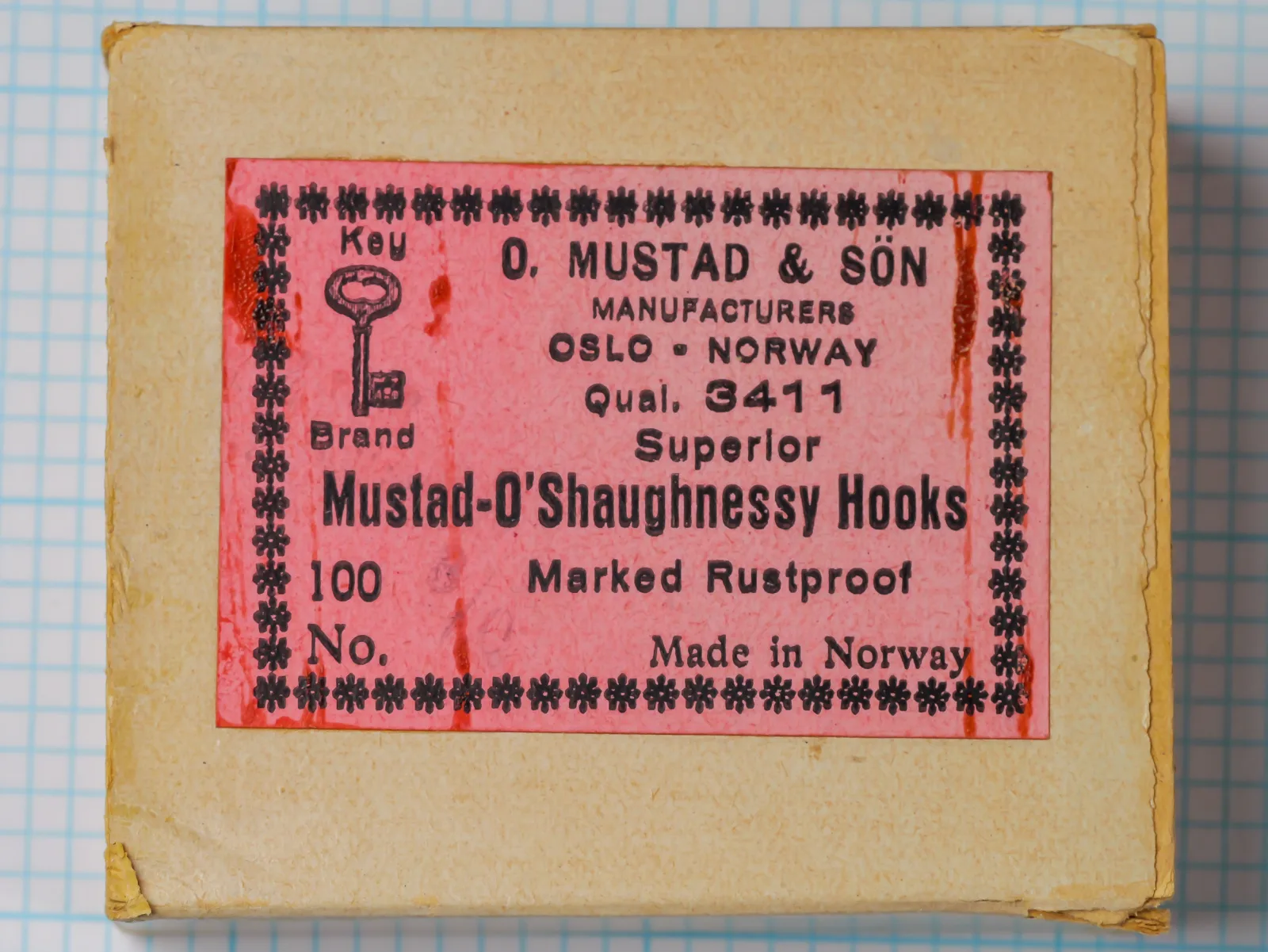 Mustad 3411 — pink eight-line label and original kraft cardboard box — size 3/0 — showing Key Brand trademark and Oslo Norway address