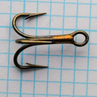 Mustad 3563 Size 10 Treble Hook — side profile view — showing ringed eye and Sproat bend geometry — bronzed finish — measurement grid background