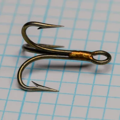 Mustad 3563 Size 10 Treble Hook — front-face close-up — showing point geometry and barb placement — hollow-point profile — bronzed finish