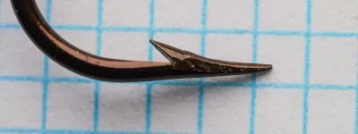 Mustad 3751 Size 19 — close-up profile of point and barb — hollow point geometry — bronzed finish