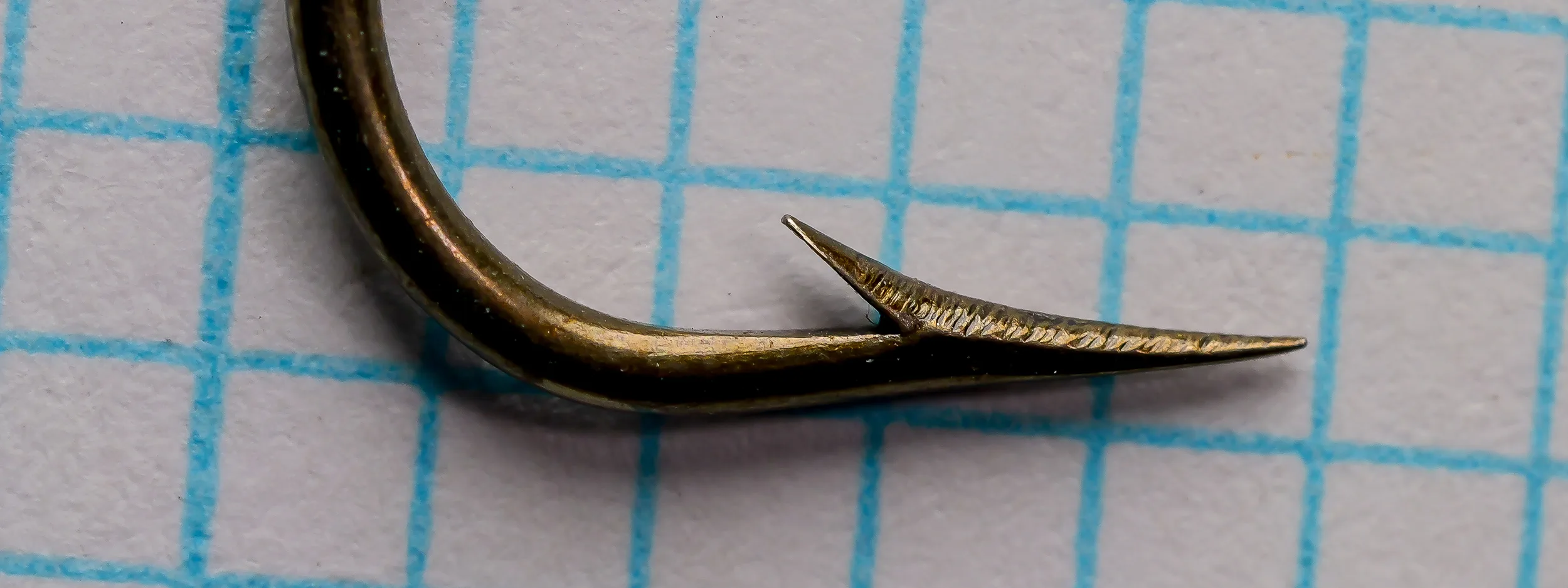 Mustad Qual. 3896 Sproat size 3/0 — side profile showing parabolic Sproat bend and marked shank ridges